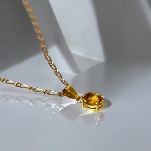 551 - An 18ct gold & Citrine ladies pendant. On a 9ct gold Figaro link chain.