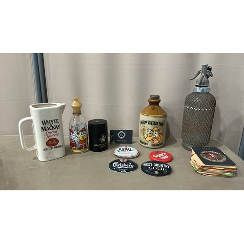 141 - Collection of four vintage bar pump badges and a vintage cider jug, featuring Aspall, Carlsberg, and... 