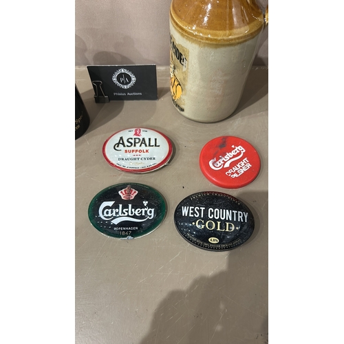 141 - Collection of four vintage bar pump badges and a vintage cider jug, featuring Aspall, Carlsberg, and... 