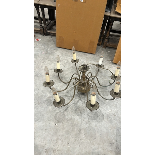 191 - Vintage brass chandelier with eight arms, featuring a classic scroll design and candle-style bulb ho... 