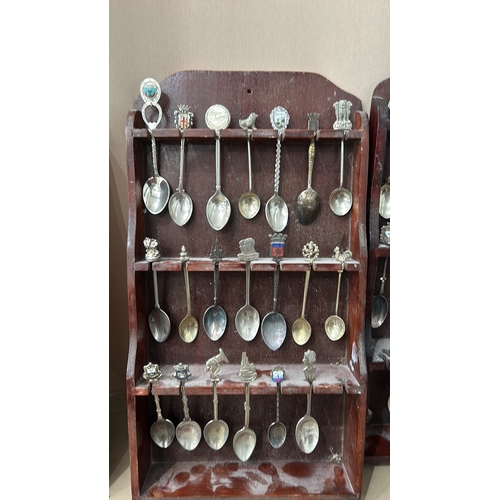 109 - A collection of vintage souvenir spoons with intricate decorative finials, housed in four wooden dis... 