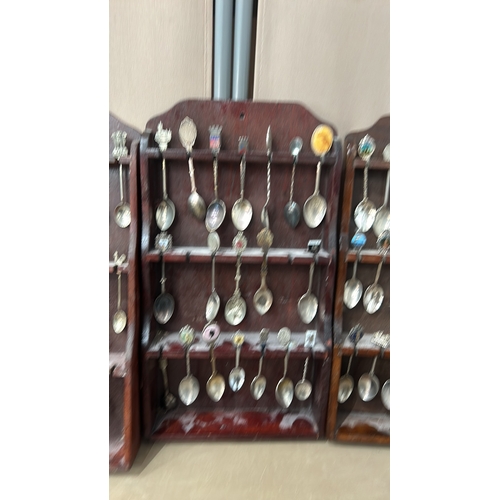 109 - A collection of vintage souvenir spoons with intricate decorative finials, housed in four wooden dis... 