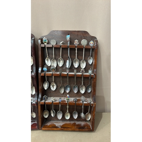 109 - A collection of vintage souvenir spoons with intricate decorative finials, housed in four wooden dis... 