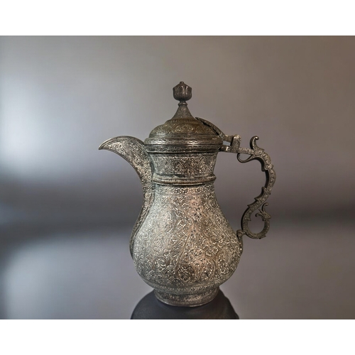 601 - A 19th century Persian tinned-copper coffee pot / Dallah.Elaborately engraved with stylised patterns... 