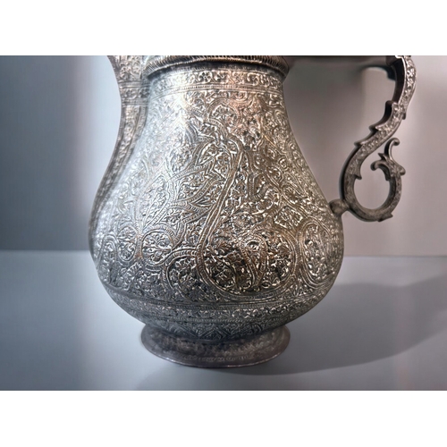601 - A 19th century Persian tinned-copper coffee pot / Dallah.Elaborately engraved with stylised patterns... 