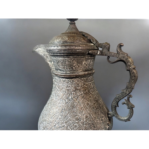 601 - A 19th century Persian tinned-copper coffee pot / Dallah.Elaborately engraved with stylised patterns... 