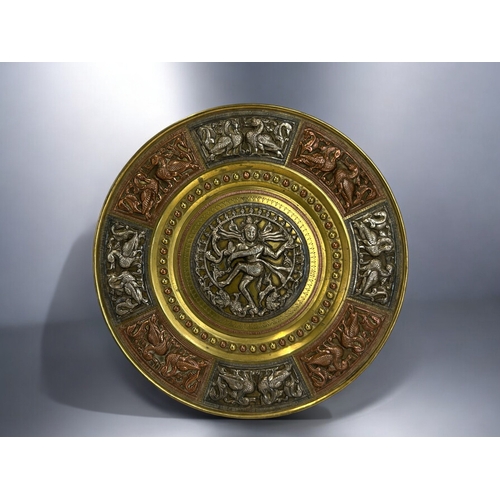 604 - An Indian mixed metal tray.Relief decorated central silver roundel depicting Shiva. Bordered with si... 