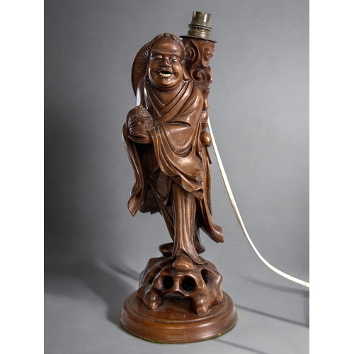 78A - A Chinese carved rootwood Luohan figural lamp.Holding captive bat.Height - 42cm