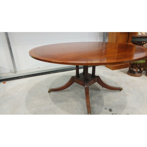 128 - Mahogany round dining table, Georgian style with pedestal base and brass casters.