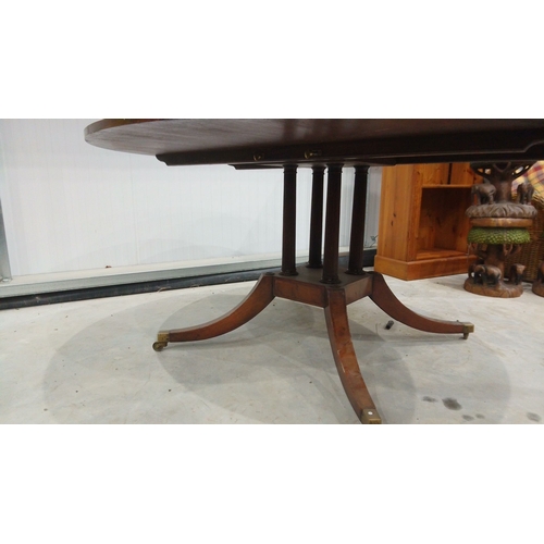 128 - Mahogany round dining table, Georgian style with pedestal base and brass casters.