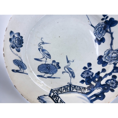 34 - A Chinese porcelain charger. Qing dynasty, Qianlong period. Decorated with Cranes & lilies, bord... 