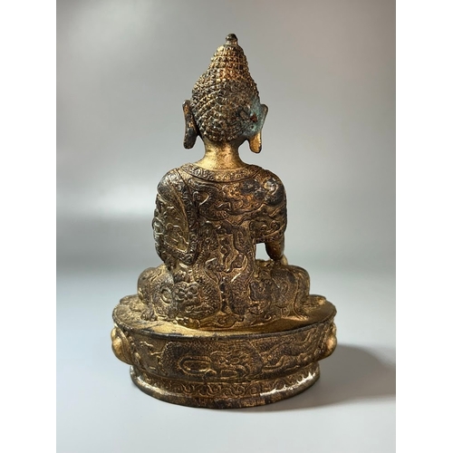 47 - A Chinese Gilt bronze Shakyamuni Buddha. 18th/19th Century. Robes adorned with scrolling Dragons. He... 