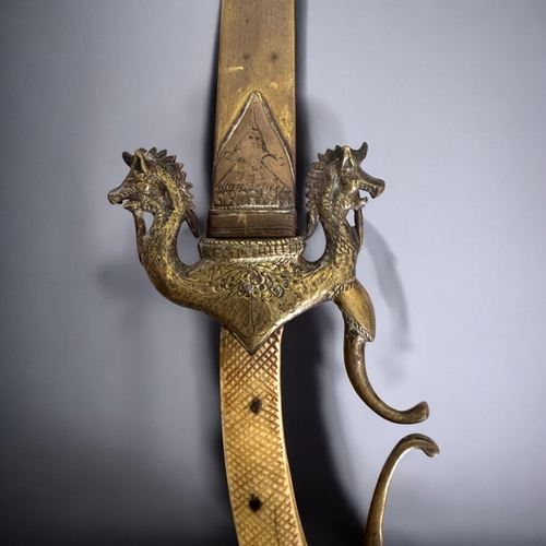 596 - A South Indian ceremonial dagger. Ornate brass Boar quillons & Elephant head pommel, with bone g... 