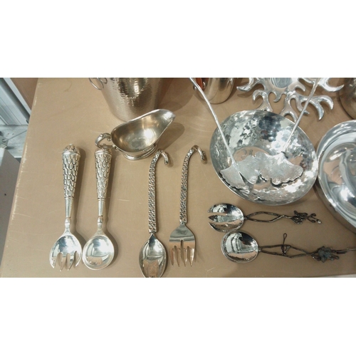 6 - Silver-plated tableware collection featuring embossed servers, hammered bowls, decorative spoons, an... 