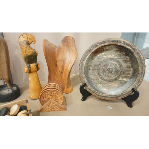 25 - Eclectic wooden decor collection: hand-carved parrots, vintage vessels, and intricate trays.