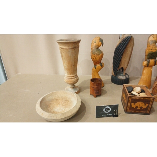 25 - Eclectic wooden decor collection: hand-carved parrots, vintage vessels, and intricate trays.