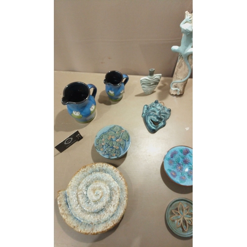 53 - Eclectic pottery collection featuring hand-painted pitchers, decorative plates, sculptural accents, ... 