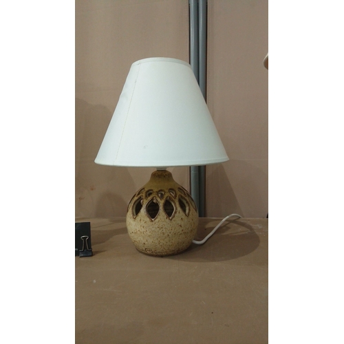 31 - Includes a brass column lamp with a cream shade, a ceramic lamp with a pierced base, and a floral-th... 