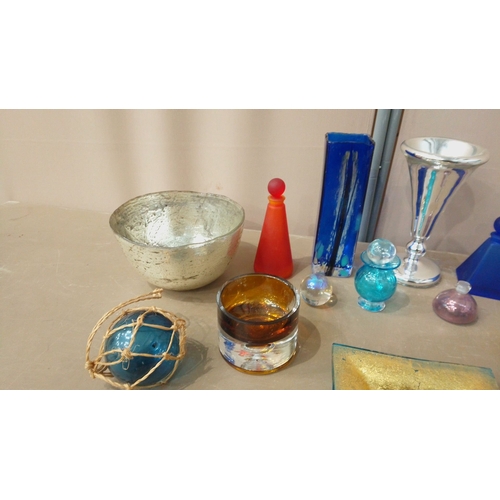 38 - Glassware collection features vibrant art glass vases, decorative bowls, silver accents, and colorfu... 