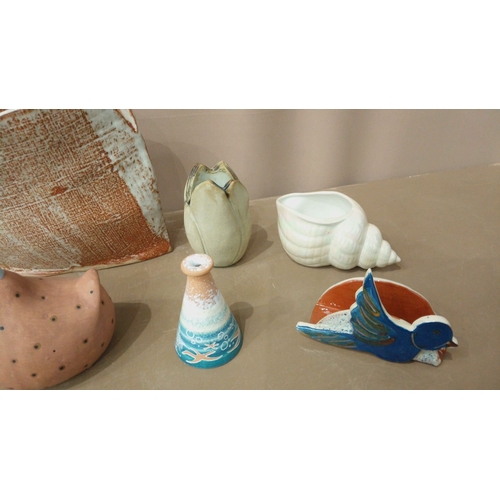 39 - Eclectic pottery collection features ceramic vessels, decorative figurines, and abstract forms. Vari... 