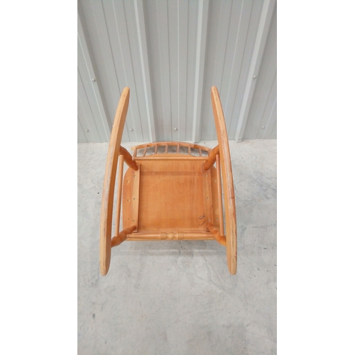 43 - Solid wood rocking chair with spindle back and curved arms, featuring a warm honey-toned finish.