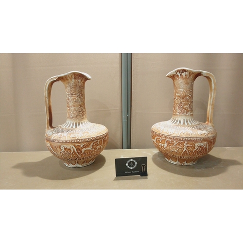 100 - Pair of vintage Greek ceramic ewers, embossed with intricate mythological motifs and geometric patte... 