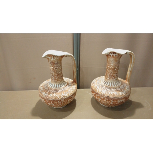 100 - Pair of vintage Greek ceramic ewers, embossed with intricate mythological motifs and geometric patte... 