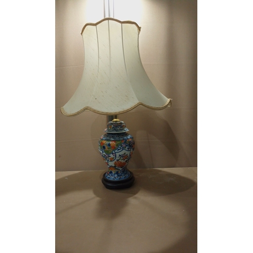 109 - Hand-painted porcelain table lamp features vibrant Imari-style floral motifs, mounted on a wooden ba... 