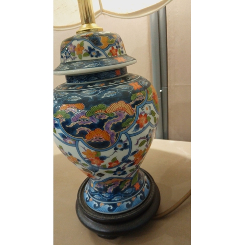 109 - Hand-painted porcelain table lamp features vibrant Imari-style floral motifs, mounted on a wooden ba... 