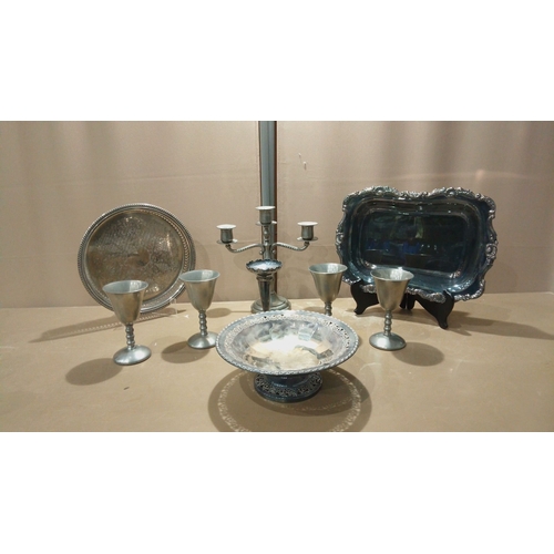 114 - Silver-plated serving set includes an ornate rectangular tray, intricately engraved round tray, and ... 