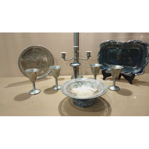 114 - Silver-plated serving set includes an ornate rectangular tray, intricately engraved round tray, and ... 