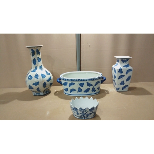 117 - Set of four porcelain pieces decorated in cobalt blue butterfly motifs, including vases, a handled d... 