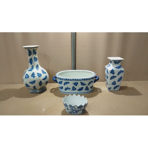 117 - Set of four porcelain pieces decorated in cobalt blue butterfly motifs, including vases, a handled d... 