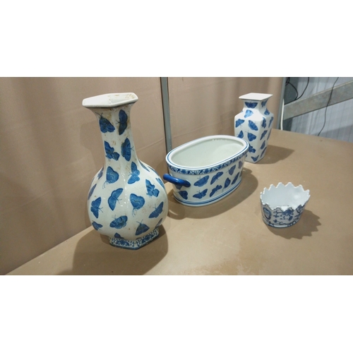 117 - Set of four porcelain pieces decorated in cobalt blue butterfly motifs, including vases, a handled d... 