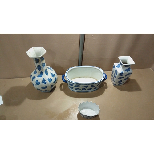 117 - Set of four porcelain pieces decorated in cobalt blue butterfly motifs, including vases, a handled d... 