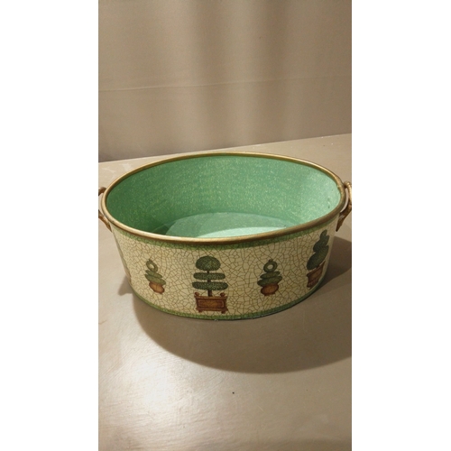 118 - Oval metal planter, hand-painted with a topiary motif and a vibrant green interior. Signed 