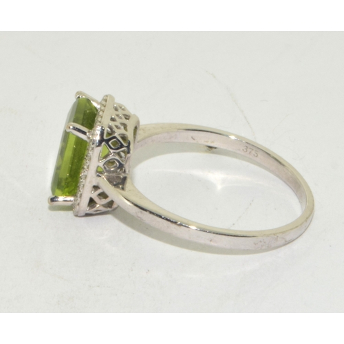 195 - 9ct white gold ladies oblong faceted peridot centre stone with a Diamond halo statement ring 3g size... 