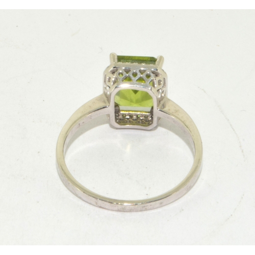 195 - 9ct white gold ladies oblong faceted peridot centre stone with a Diamond halo statement ring 3g size... 