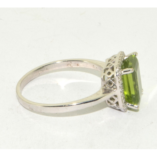 195 - 9ct white gold ladies oblong faceted peridot centre stone with a Diamond halo statement ring 3g size... 