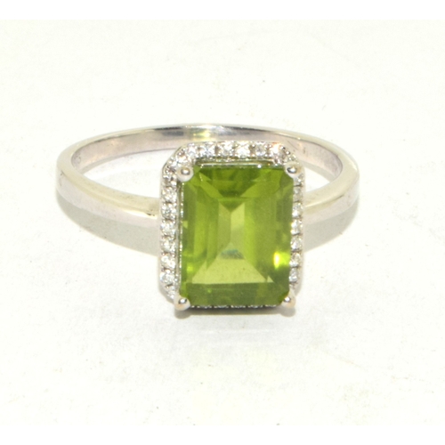 195 - 9ct white gold ladies oblong faceted peridot centre stone with a Diamond halo statement ring 3g size... 