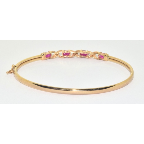 128 - 9ct gold oval cut Ruby and Diamond bangle with a Diameter of 6cm