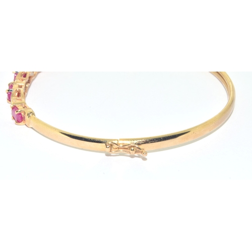 128 - 9ct gold oval cut Ruby and Diamond bangle with a Diameter of 6cm