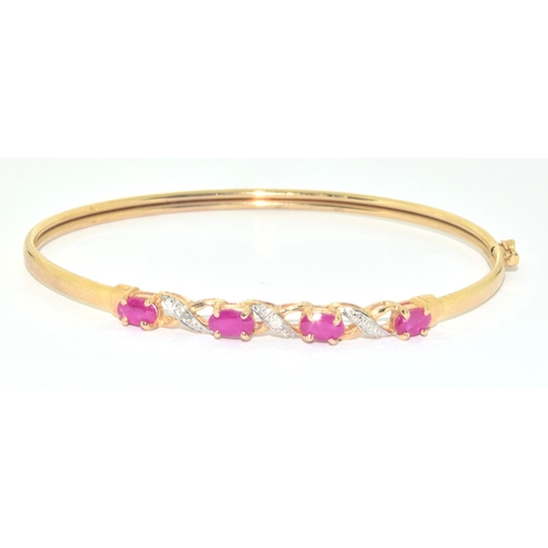 128 - 9ct gold oval cut Ruby and Diamond bangle with a Diameter of 6cm