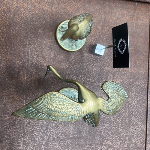 60 - Pair of cast brass crane statuettes, one standing erect, the other bending to feed, each on a textur... 