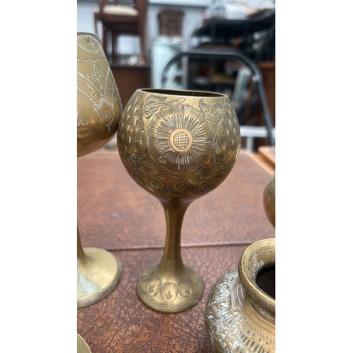 62 - Group of six Indian engraved brass wares: three stemmed goblets, a squat pot and two circular dishes... 