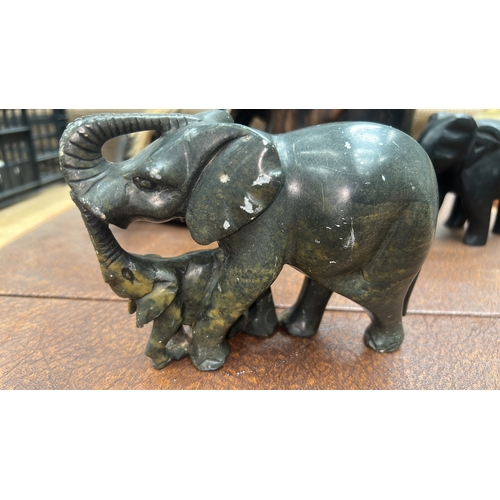 9 - Four African hand-carved ornaments: mottled green serpentine elephant with calf, grained hardwood el... 
