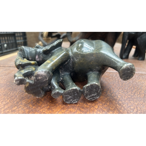 9 - Four African hand-carved ornaments: mottled green serpentine elephant with calf, grained hardwood el... 