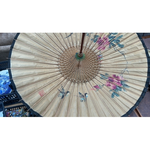 55 - Pair of bamboo-ribbed oiled-paper parasols; one cream ground with polychrome floral sprays, the othe... 