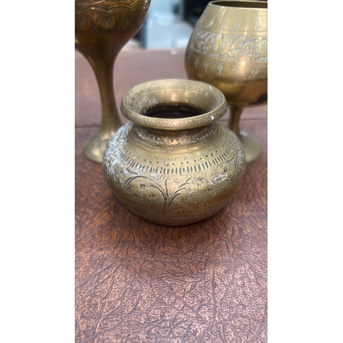 62 - Group of six Indian engraved brass wares: three stemmed goblets, a squat pot and two circular dishes... 
