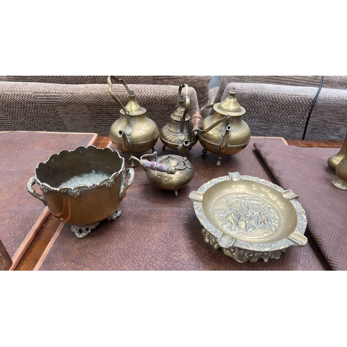 63 - Collection of six decorative brass items comprising four small footed kettles with wooden swing hand... 